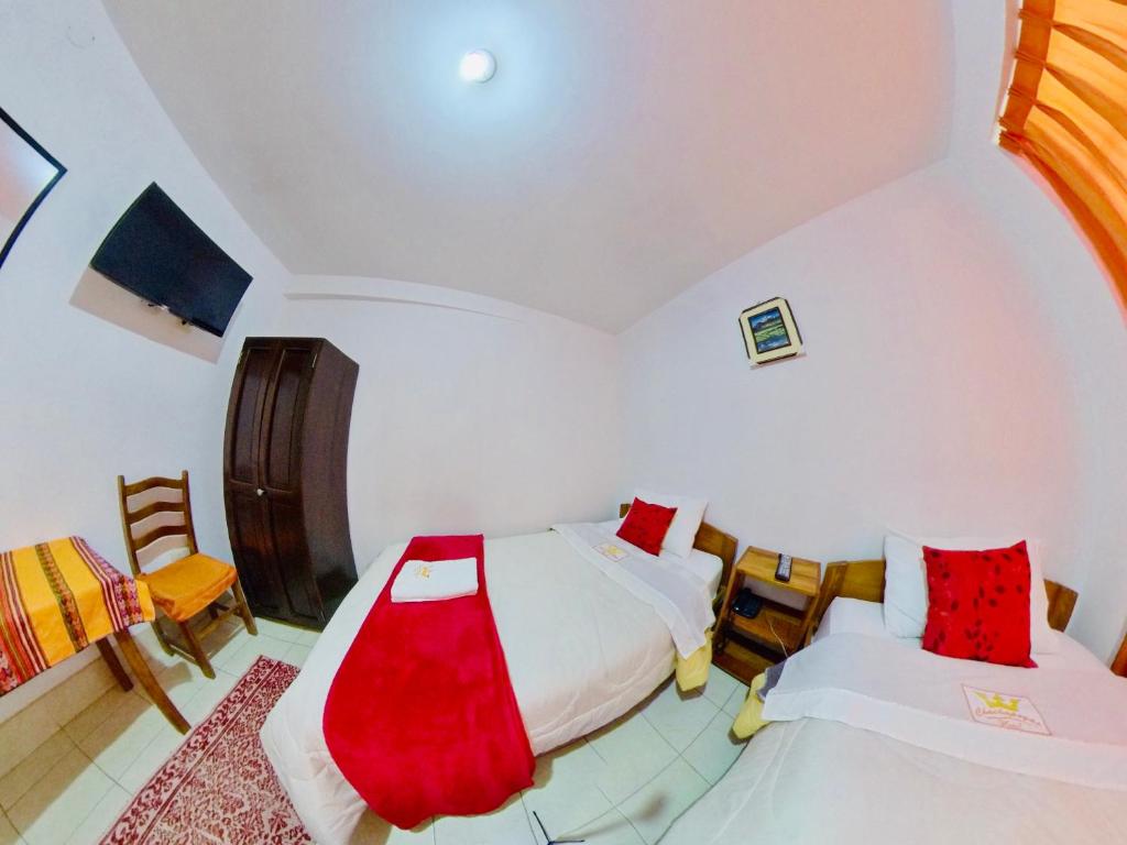 a bedroom with two beds and a table and chairs at Hotel Chachapoyas in Chachapoyas