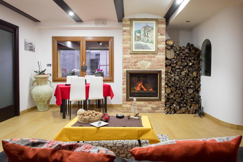 a living room with a table and a fireplace at B&B Didova in Gavoi