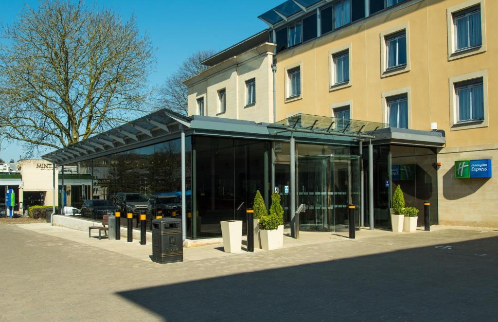 a building with a glass fronted building with potted plants at Holiday Inn Express Bath, an IHG Hotel in Bath