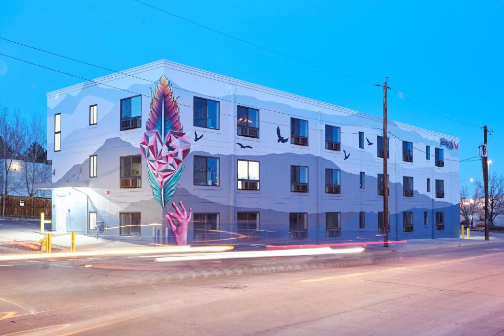 a white building with a painting on the side of it at Sonder Osage in Denver