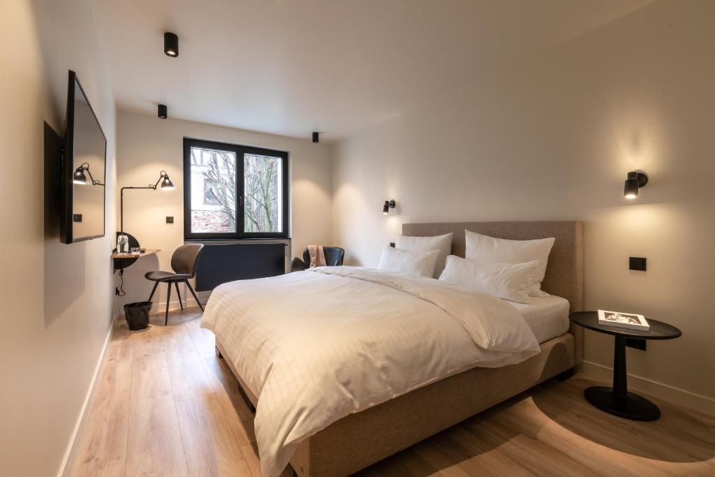 a bedroom with a large bed and a desk at THE ADAMS - Self Check In Hotel in Baden-Baden