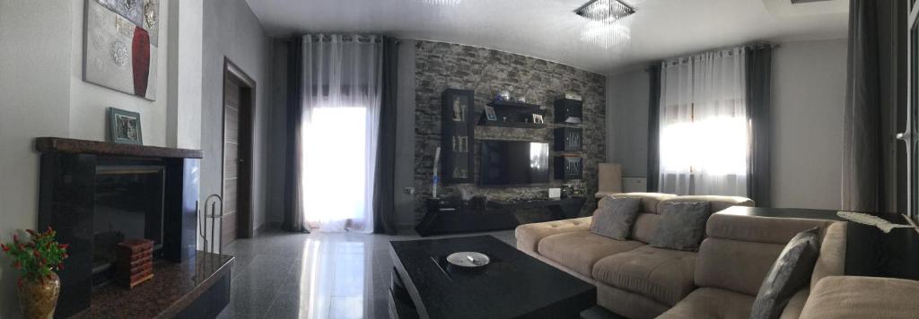 een woonkamer met een bank en een open haard bij Mario’s house in Vergina