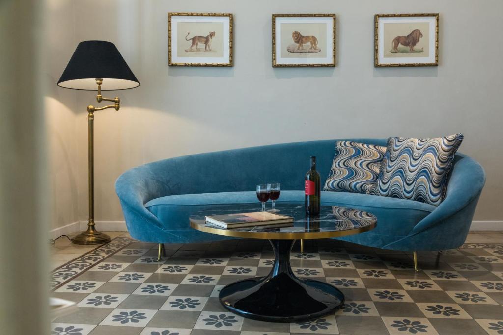 - un canapé bleu dans un salon avec une table dans l'établissement Dimora Minima, à Catane