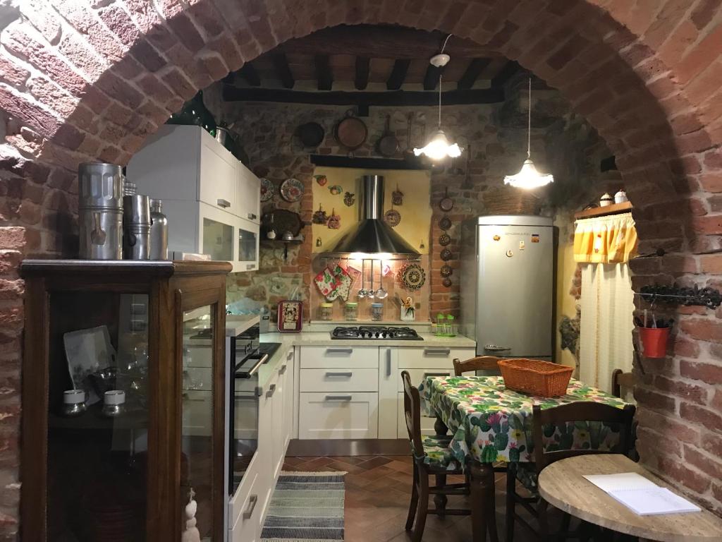cocina con mesa y pared de ladrillo en Casa Ravi, en Gavorrano