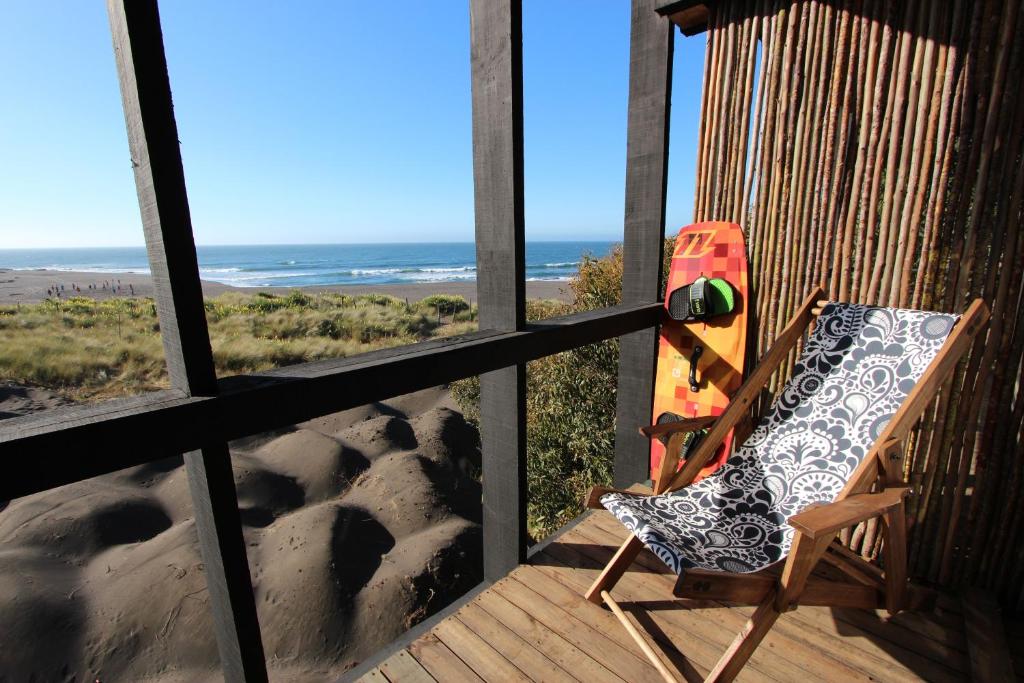 a deck with a chair and a skateboard on the beach at Hotel Punta Sirena in Curanipe