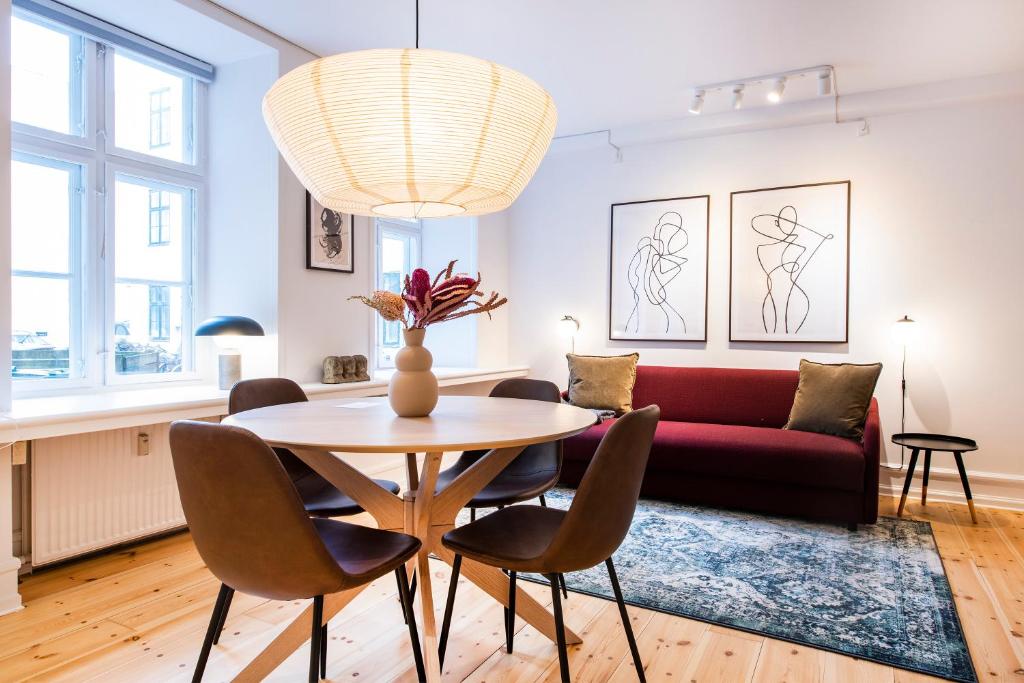 sala de estar con mesa y sofá rojo en Town Hall Apartments by Daniel&Jacob's, en Copenhague