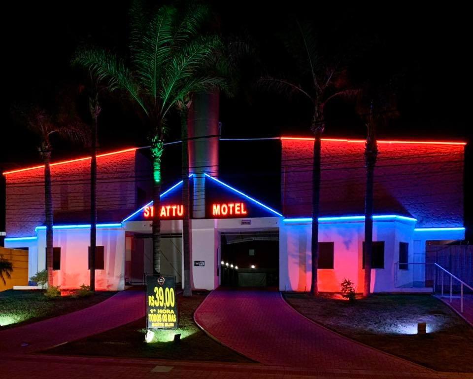 um motel iluminado à noite com luzes vermelhas e azuis em Motel Strattus (Adults Only) em Belo Horizonte