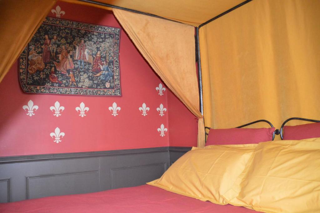 a bedroom with a canopy bed and a painting on the wall at Au fil du temps in Amboise