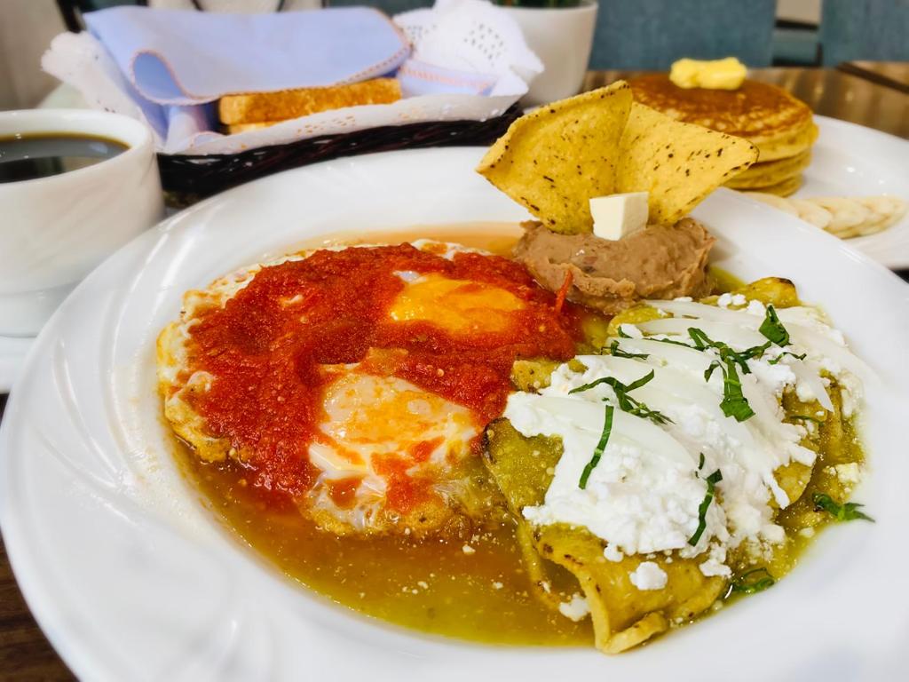 A Mexican-style breakfast plate with eggs, enchiladas and beans.