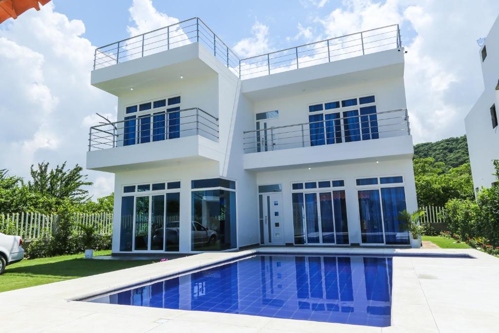 a house with a swimming pool in front of it at VILLA MANDALAY in Santa Veronica
