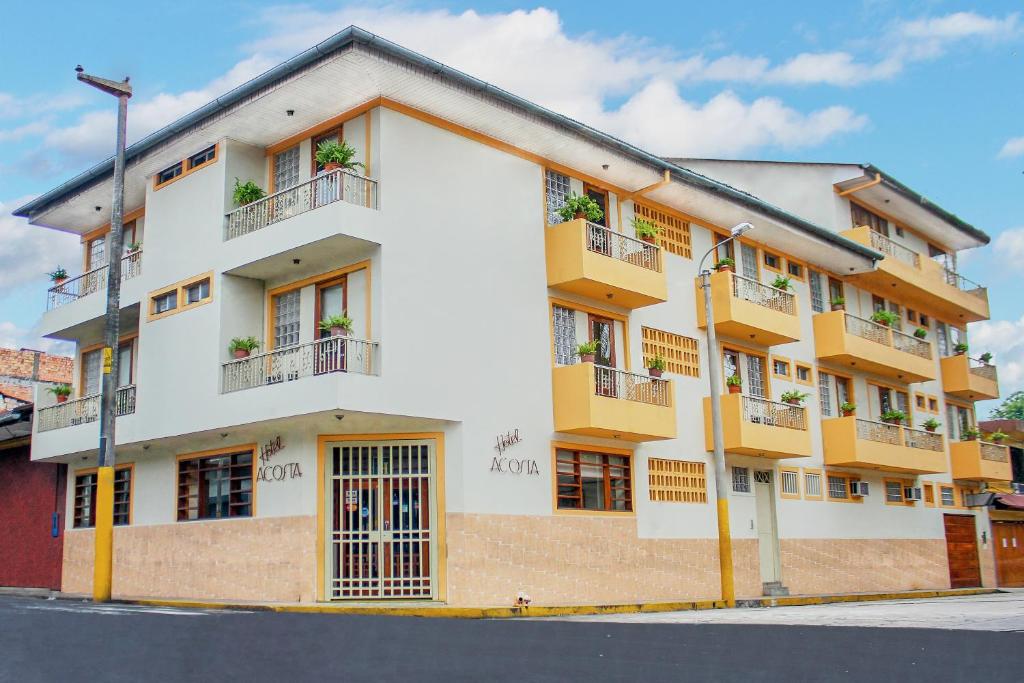 a building with balconies on a city street at Hotel Acosta in Iquitos