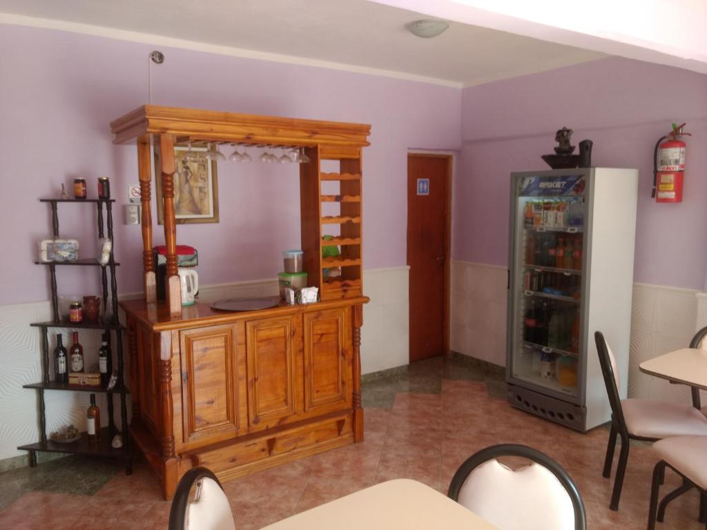 Cette chambre comprend un réfrigérateur, une table et des chaises. dans l'établissement Hotel Las Moras, à La Rioja