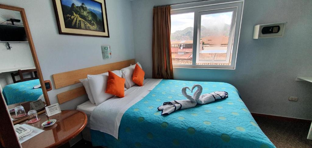 Una habitación de hotel con una cama con una toalla. en HOTEL AMTALLPA San Blas Inn, en Cusco