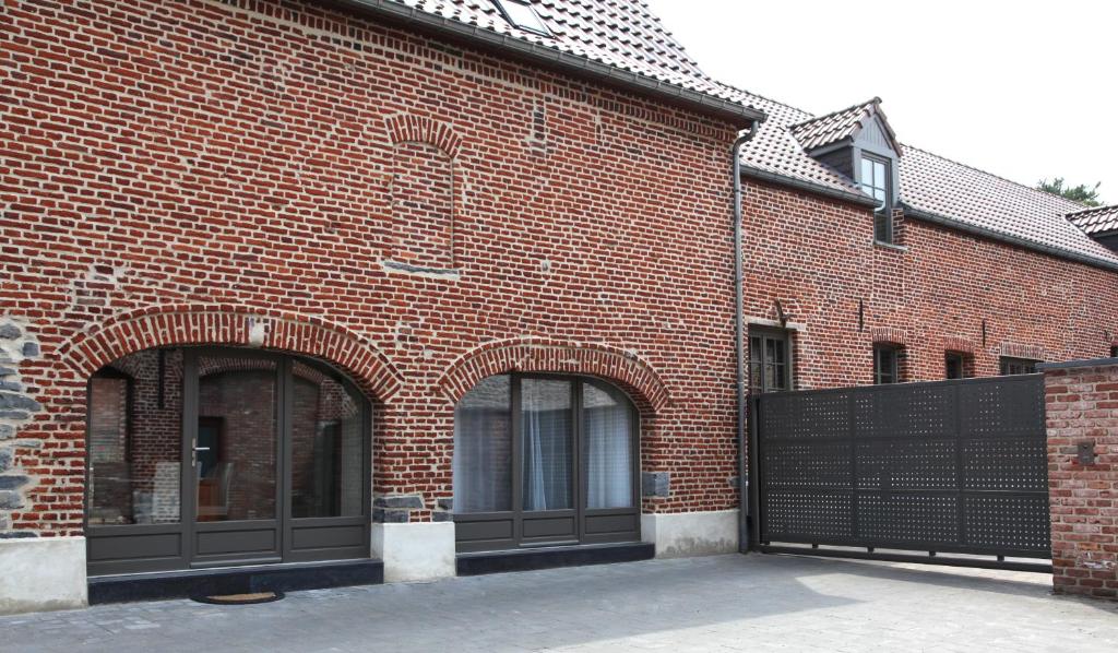 un bâtiment en briques rouges avec une porte noire dans l'établissement Au Moulin à Paroles, à Tournai