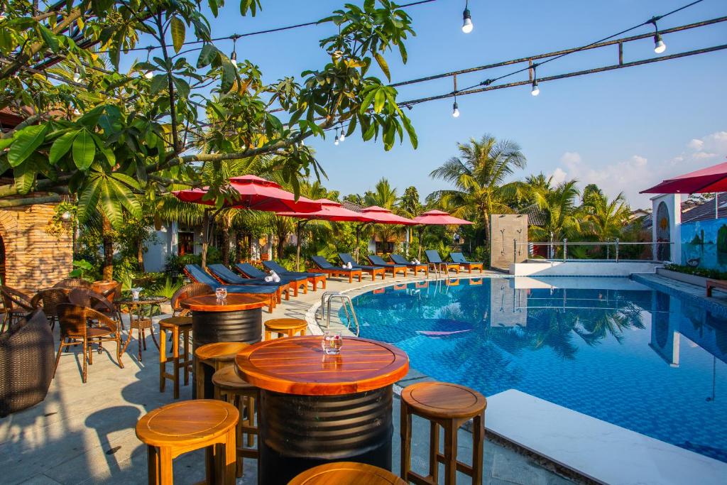 un hotel con una piscina con mesas y sillas en Palm Hills Resort, en Phu Quoc