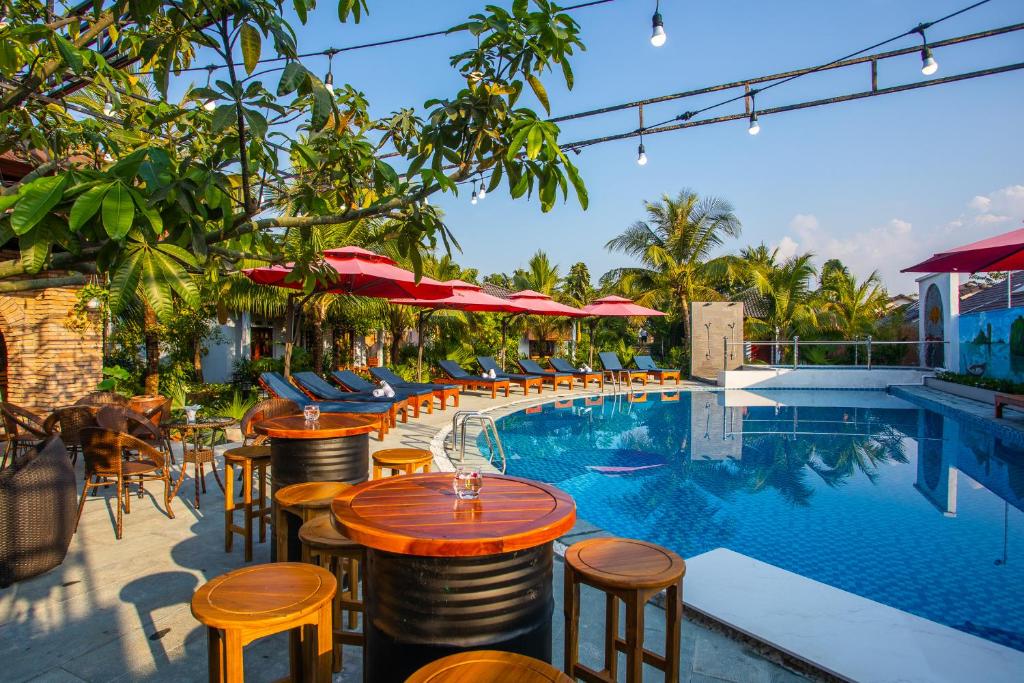 a hotel with a pool with tables and chairs at Palm Hills Resort in Phu Quoc