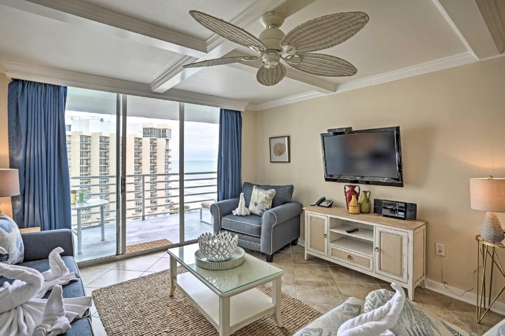 een woonkamer met een plafondventilator en een televisie bij Beachfront Condo with Resort Amenities and Boardwalk! in Myrtle Beach