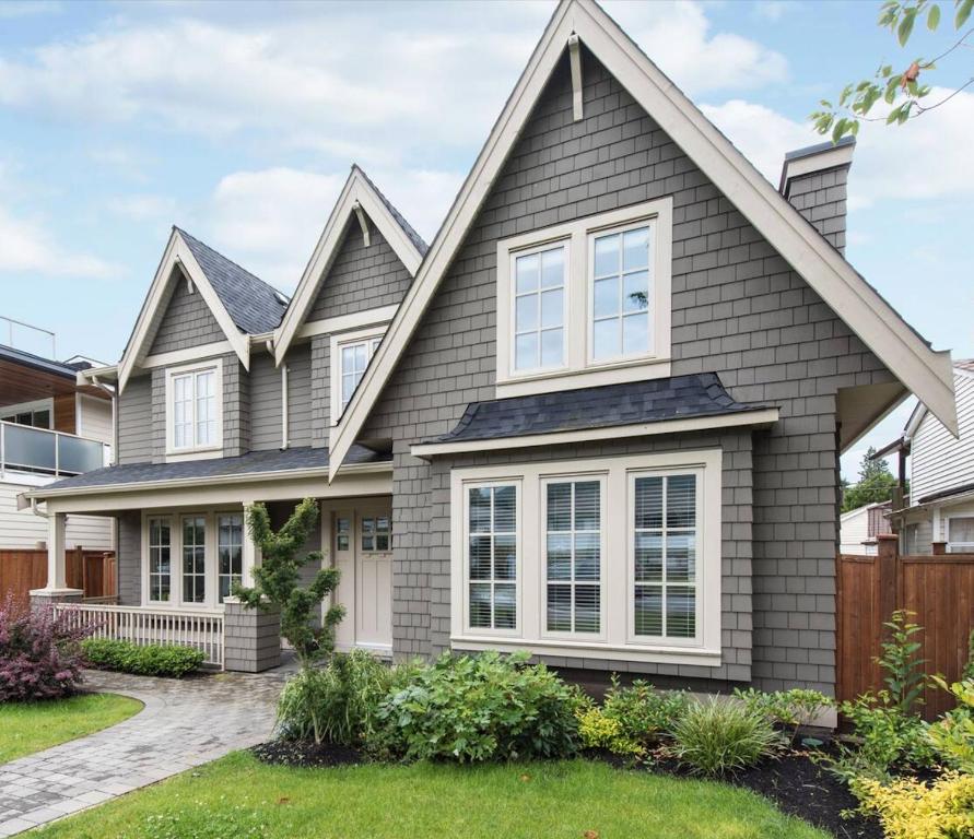 uma casa com revestimento cinzento e janelas brancas em Brand New 2 Brdm Suite - New House em North Vancouver