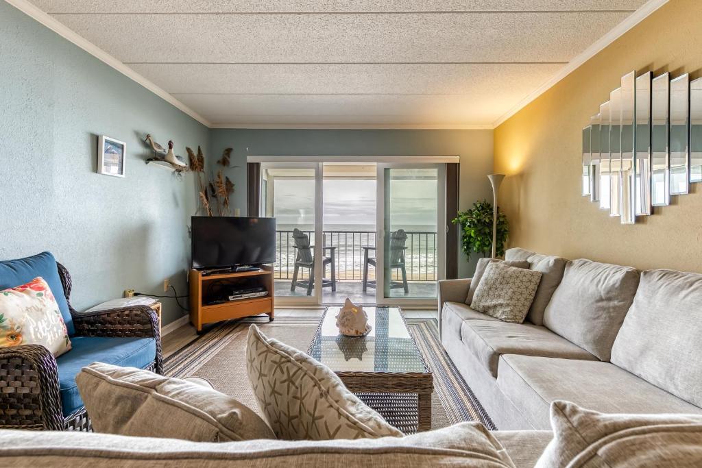 a living room with a couch and a tv at Salty Sands in Ocean City