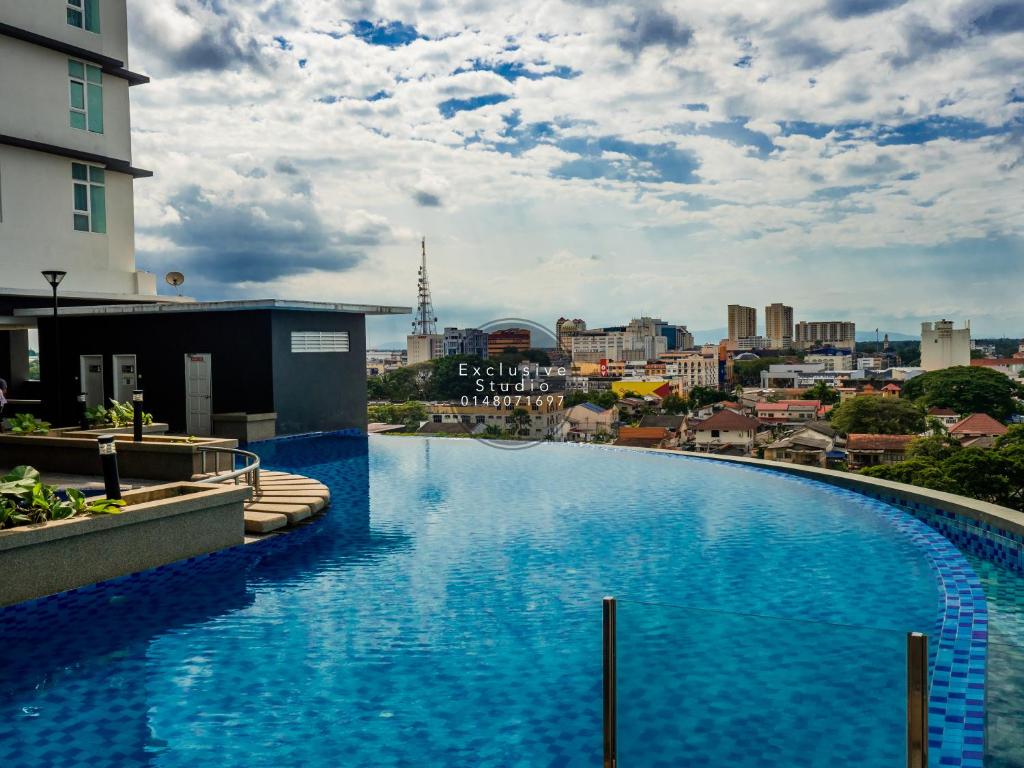 a large swimming pool with a city in the background at Studio Exclusive (D'Perdana Condominium) in Kota Bharu