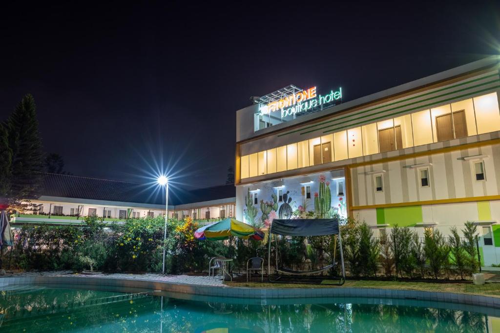 a hotel with a swimming pool at night at Three Eight Front One Boutique Batu Malang in Batu