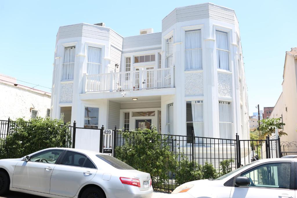 two cars parked in front of a white house at The Burlington in Los Angeles