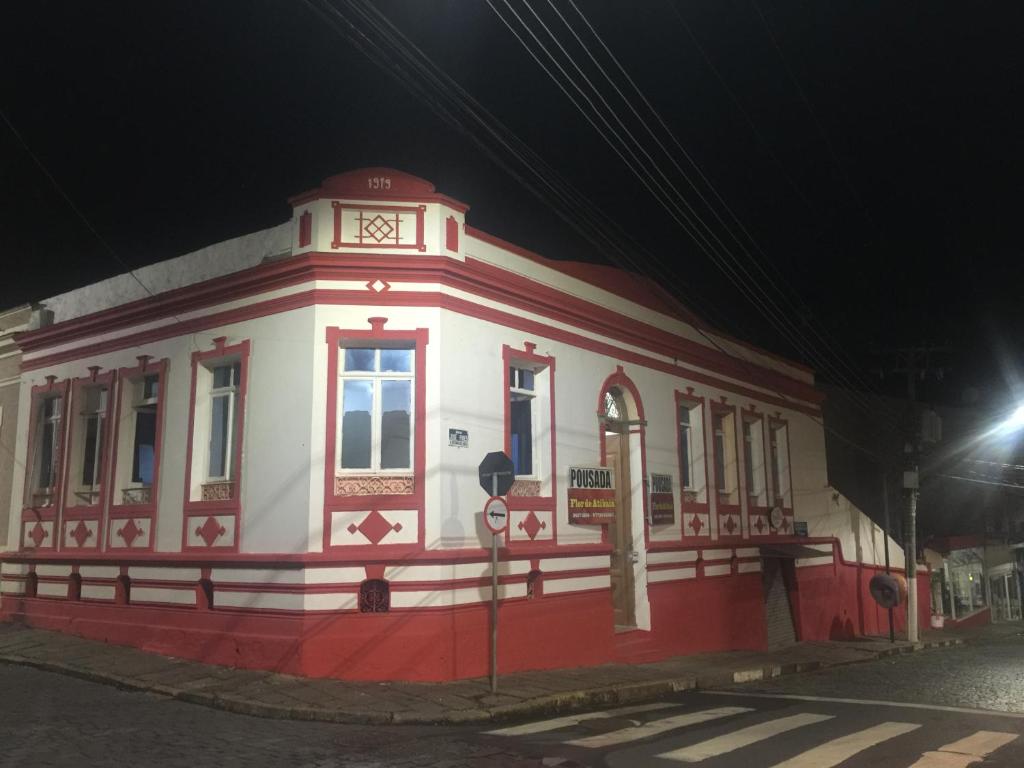 a red and white building on a street at night at Pousada flor de Atibaia in Atibaia