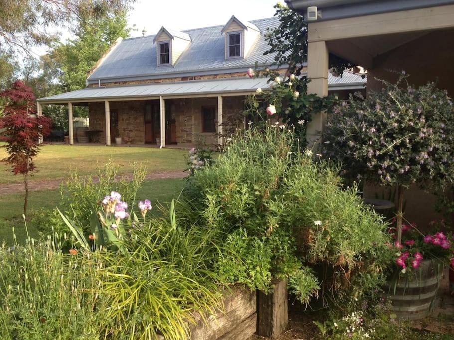 a house with a bunch of plants in front of it at The Coach House on River and Park in Mudgee