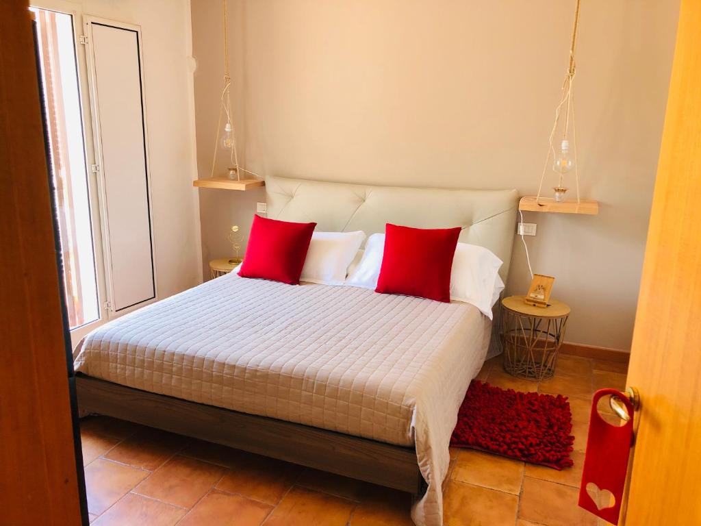 een slaapkamer met een bed met 2 rode kussens bij Baricityhouse in Bari