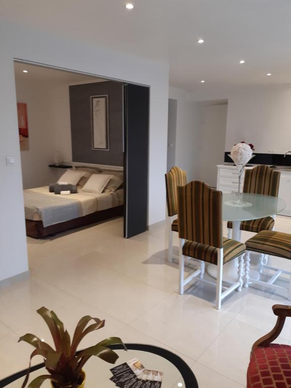 a bedroom with a bed and a table and chairs at Les Suites de Véronique, chez Véronique Olive in Saint-Pair-sur-Mer