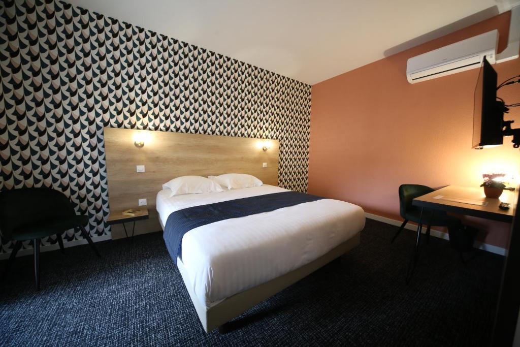 Pokój hotelowy z łóżkiem, stołem i biurkiem w obiekcie Hôtel Fontaine Argent - Centre Ville w Besançon