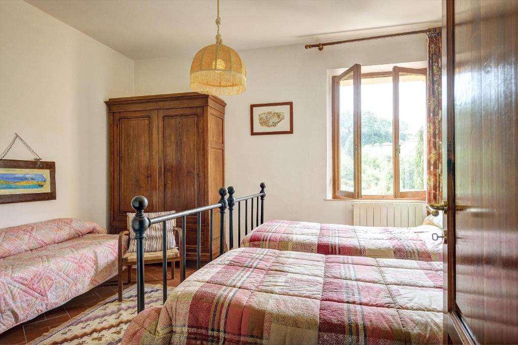 a bedroom with a bed and a window at Podere Fontecastello in Montepulciano