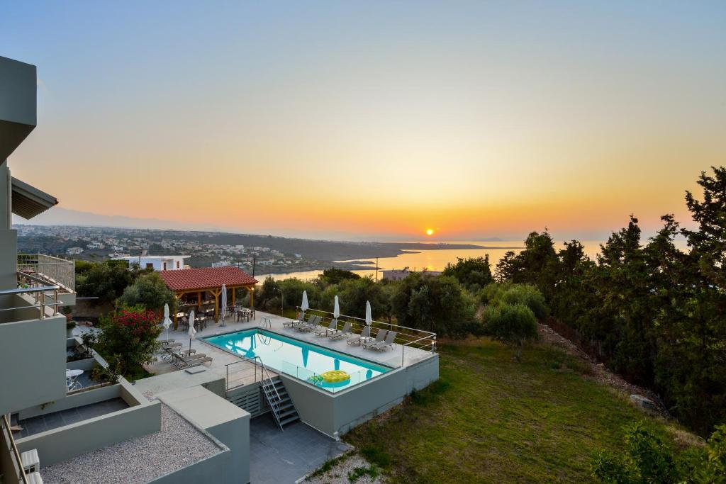 a house with a swimming pool and a sunset at Casa Manolesos in Chorafakia