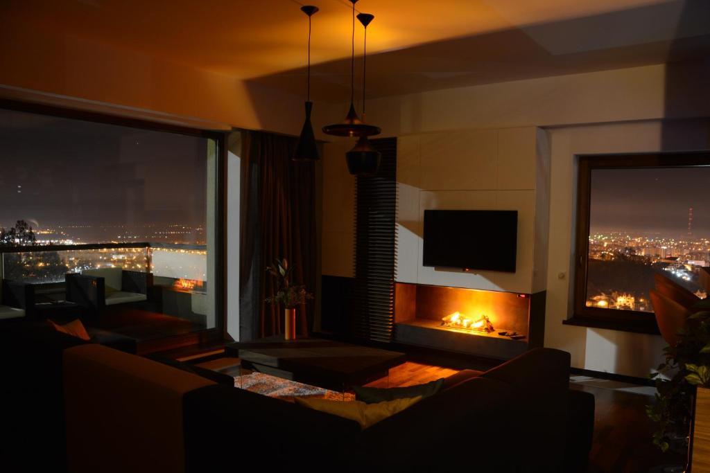 a living room with a fireplace and a view of a city at Juniper Apartment in Braşov