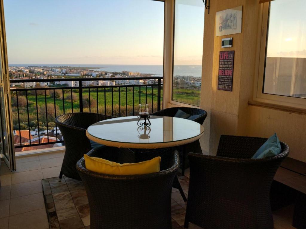 a table and chairs in a room with a window at Panoramic Eden in Paphos