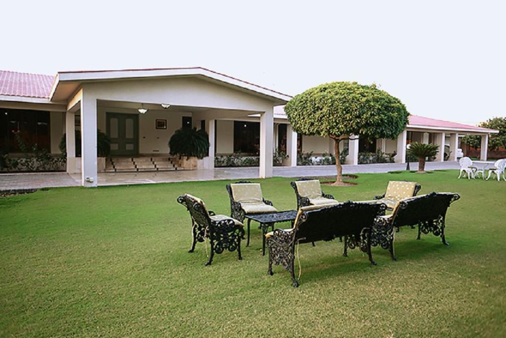 a group of chairs and tables in a yard at Etihad Club by Faletti's Hotel in Rahimyar Khan