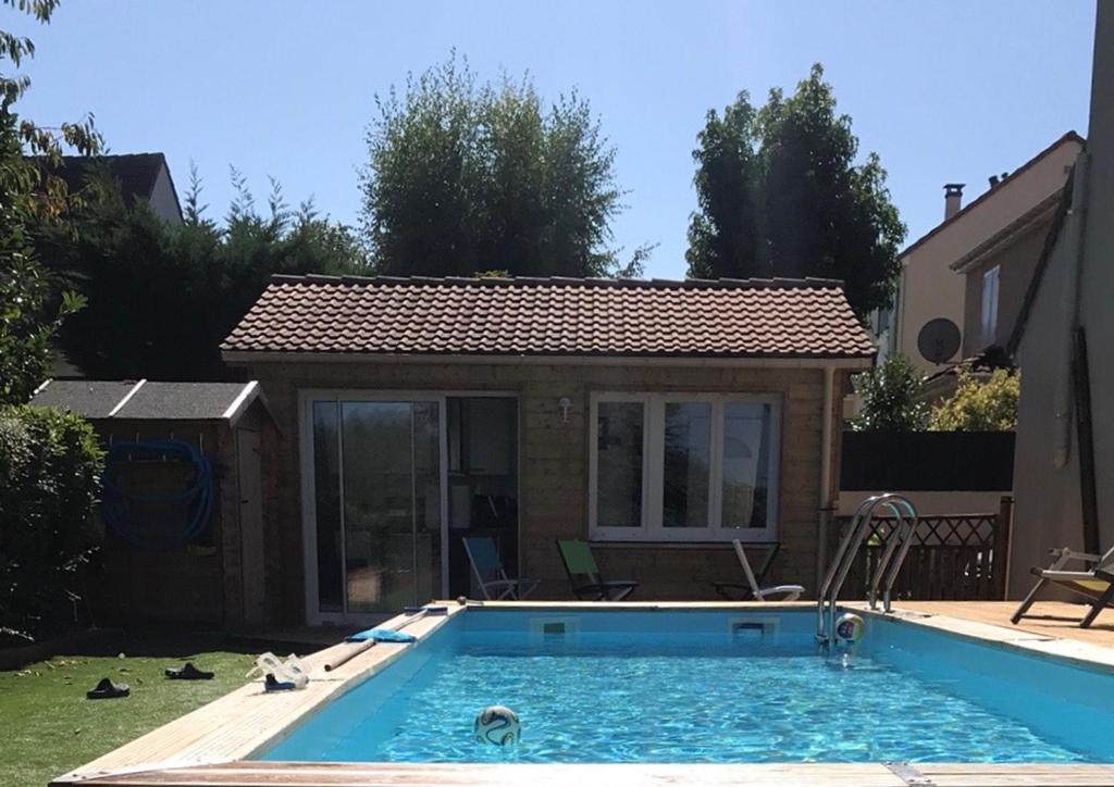 una casa con piscina en el patio en CHALET DU LAC PISCINE à 5 MINUTES DE DISNEY TGV RER, en Montévrain