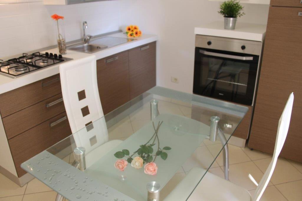 una cocina con una mesa de cristal con flores. en Mono Eraclito, en Marina di Pescoluse