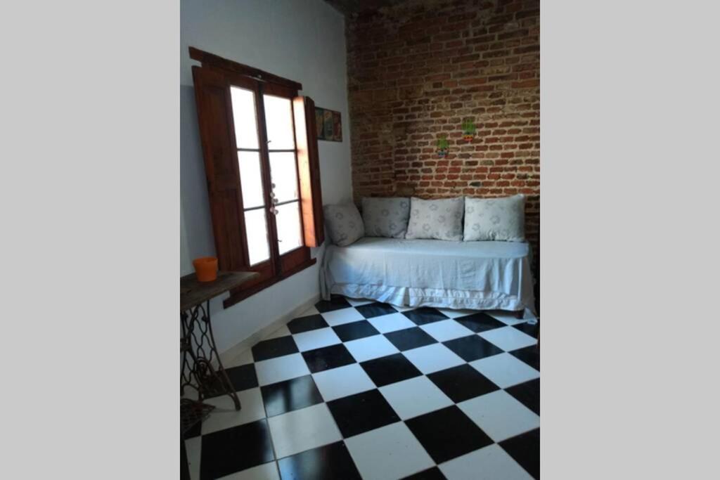 1 dormitorio con 1 cama y suelo a cuadros en Departamento Amoblado con Cochera en Villa María