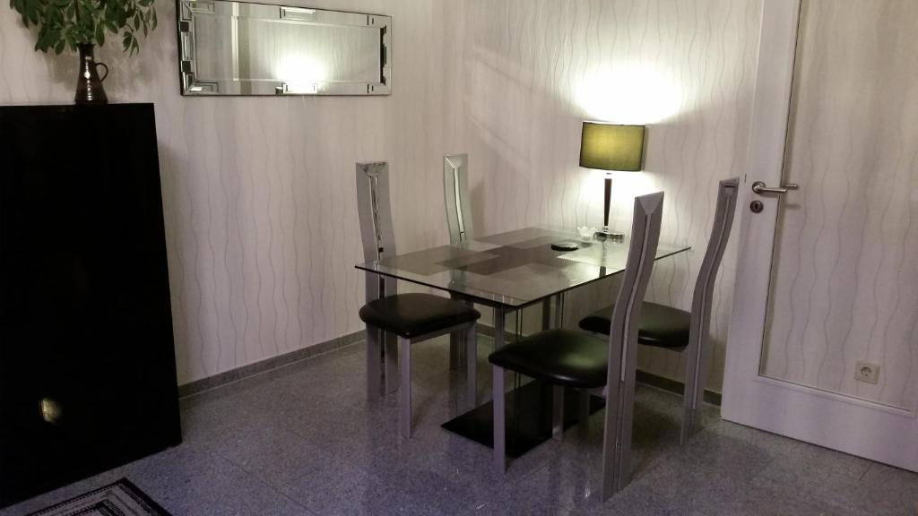 Seefeld的住宿－Seefelder Urlaubsparadies，玻璃桌,带两把椅子和一盏灯