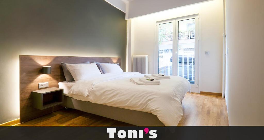 a bedroom with a large bed and a window at TONI'S 2BD Modern flat in Koukaki near Acropoli in Athens