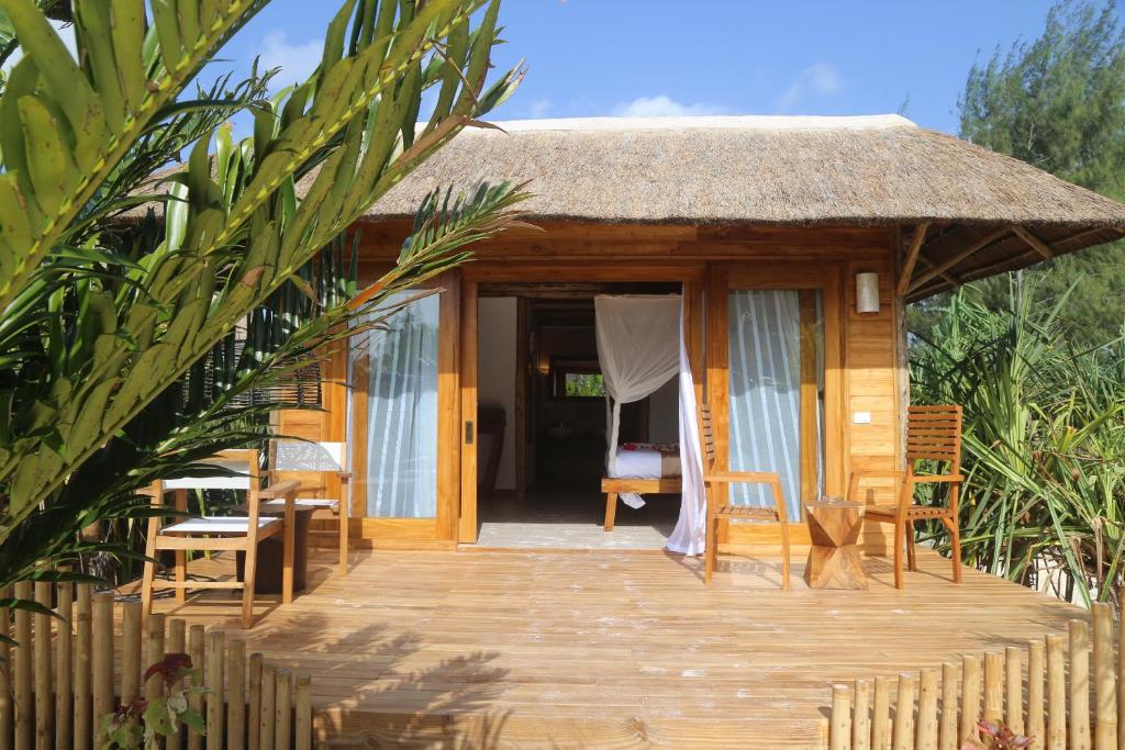 a small hut with a wooden deck and chairs at Fruit & Spice Wellness Resort Zanzibar in Kizimkazi
