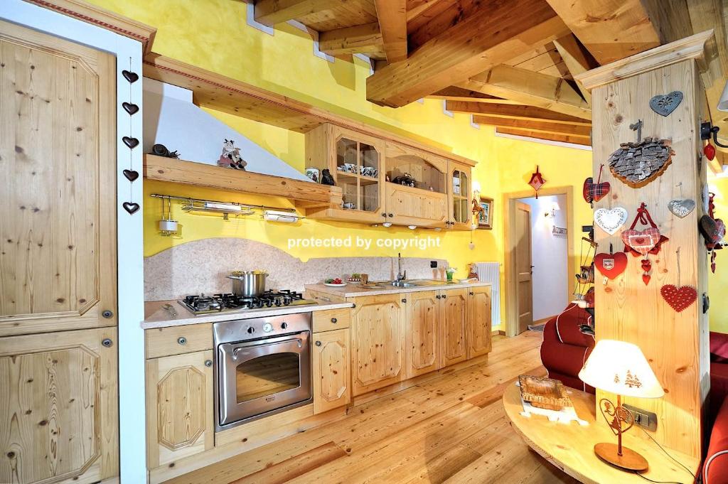 a large kitchen with wooden cabinets and a table at Luxury Exclusive Attic in Pinzolo