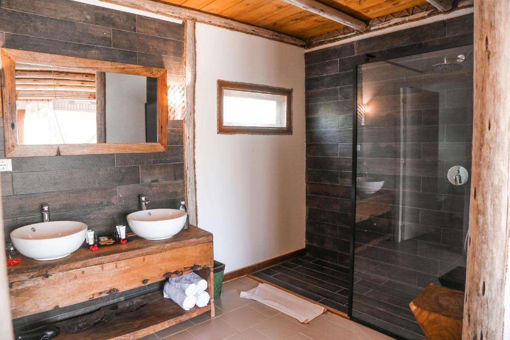 a bathroom with two sinks and a shower at Fruit & Spice Wellness Resort Zanzibar in Kizimkazi
