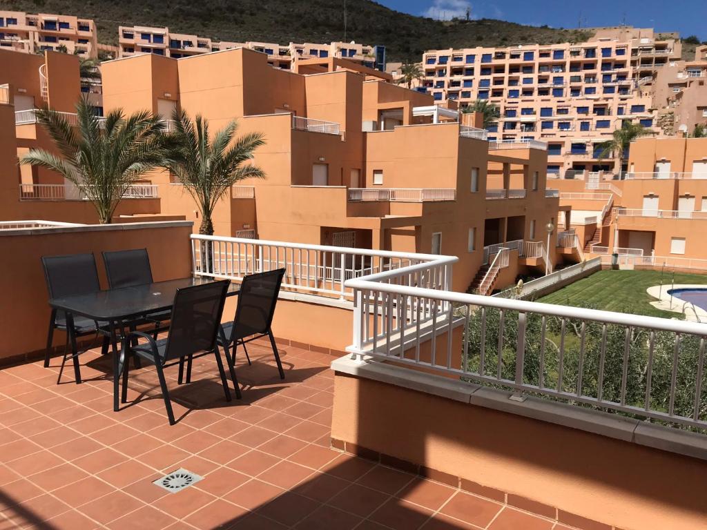 a balcony with a table and chairs and buildings at Miramar Marina de Marina Golf in Mojácar
