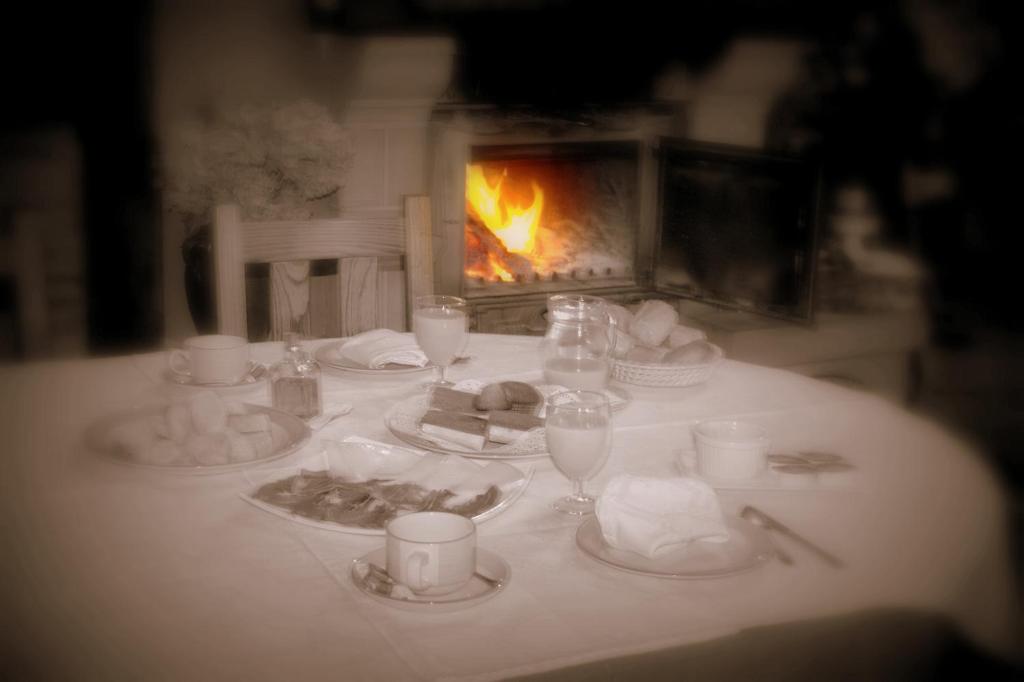 a table with plates of food and a fireplace at Perlakua Saka in Deba