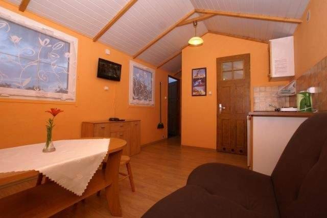 salon ze stołem i kuchnią w obiekcie Domki Ostoja w Rewalu