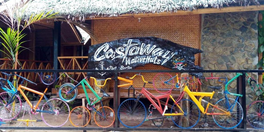 un grupo de bicicletas coloridas estacionadas frente a un edificio en Castaway Native Huts en San Vicente