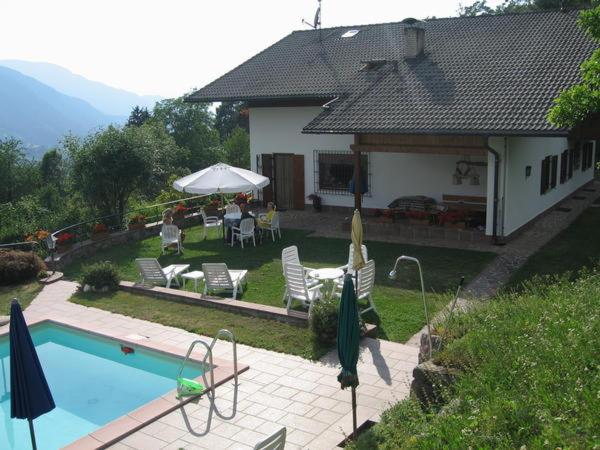 Casa con piscina, mesa y sillas en App. Eichenheim en Fiè