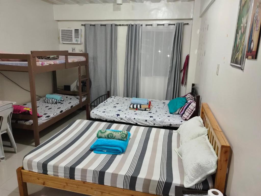 a bedroom with two bunk beds and a window at Mhavic family room ,group friend good for 6 guest in Manila
